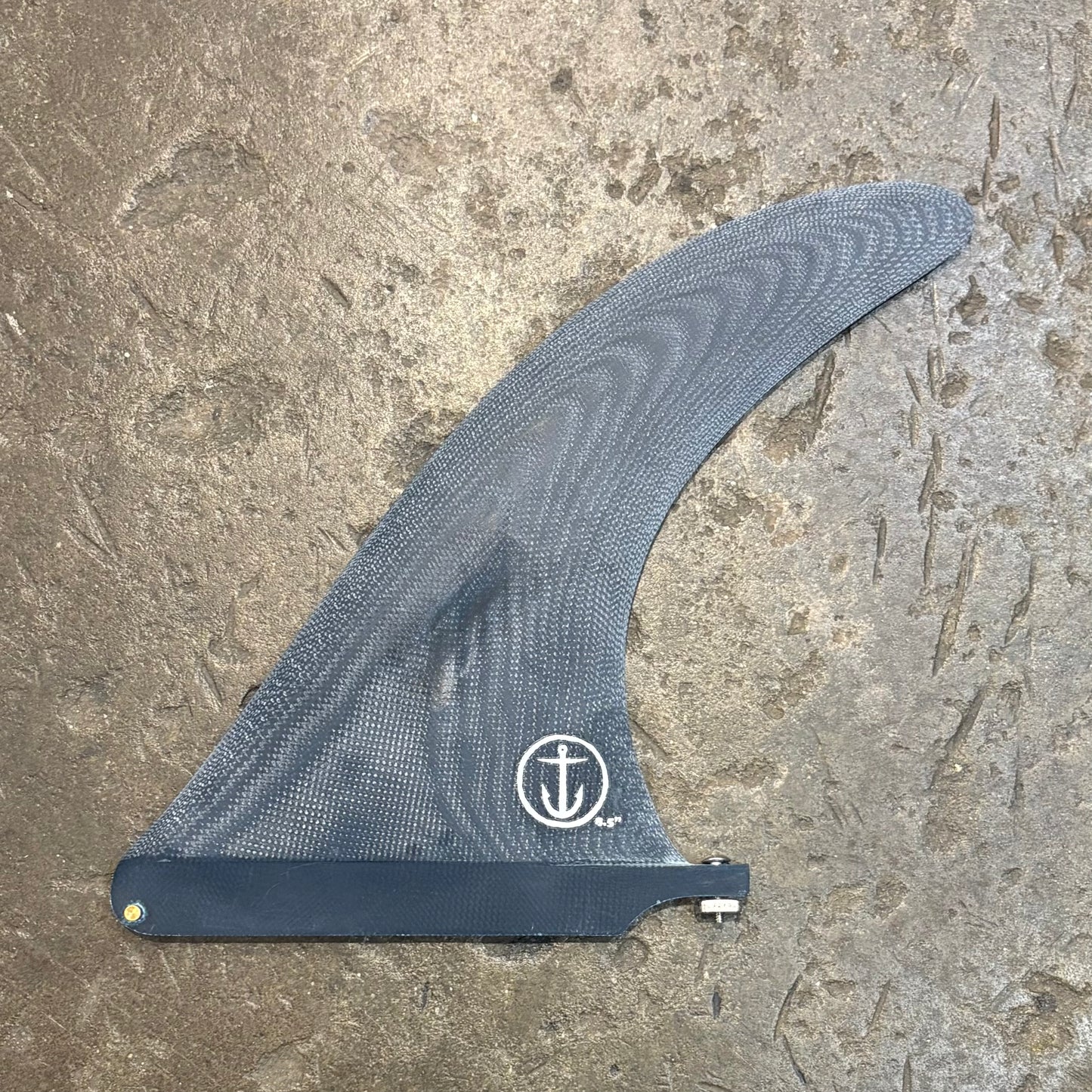 Blue surf fin with a Captain Fin logo on a textured surface