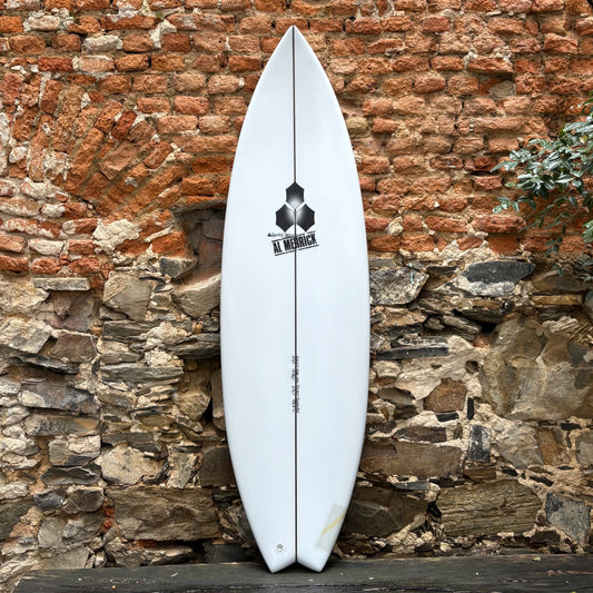 White CHANNEL ISLANDS   BETTER EVERYDAY  5'9  19 1/2  2 7/16  29.3L surfboard with a logo against a rustic stone wall