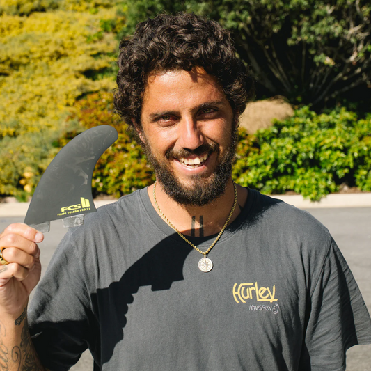 Filipe Toledo holding one of his FCS II Filipe Toledo PG Pro Fins