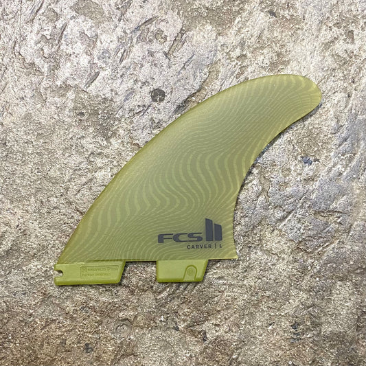 A single FCS ll Carver Neo Glass Eco Fins in the green colour way laid out on a concrete floor