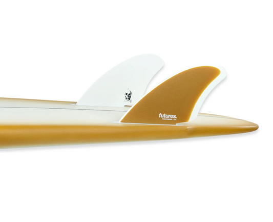 A set of Futures Christenson Keel surfboard fins in a surfboard with orange rails. One fin is white while the other is orange with a gradient, against a white background.
