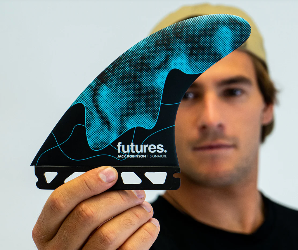 Jack Robinson holding one of his signature Futures fins in the black and blue colour way.