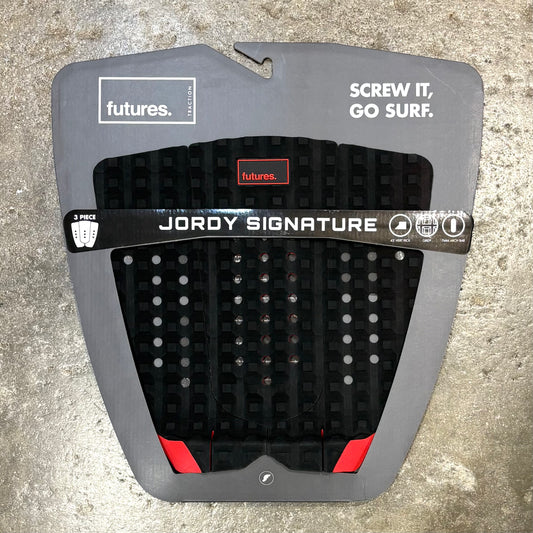 Jordy Smith signature surfboard tail pad in a black and red colour way on a textured surface