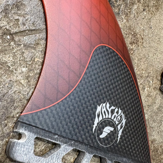 Close-up of a red and black set of Futures Mayhem 3.0 Large with a brand logo on a textured surface.