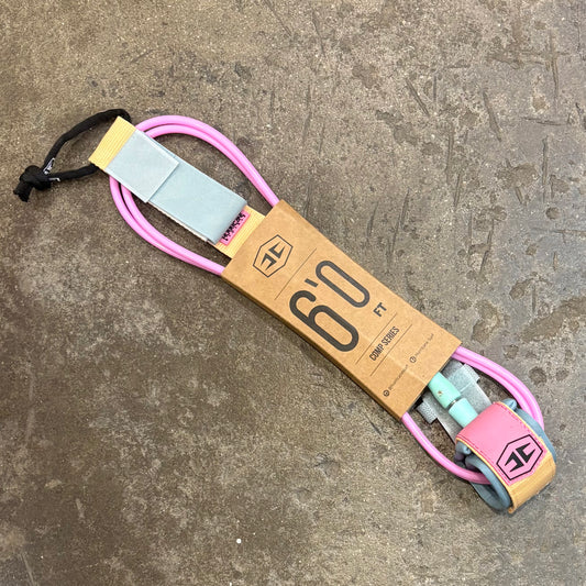 Surfboard leash with pink and blue straps on a concrete surface