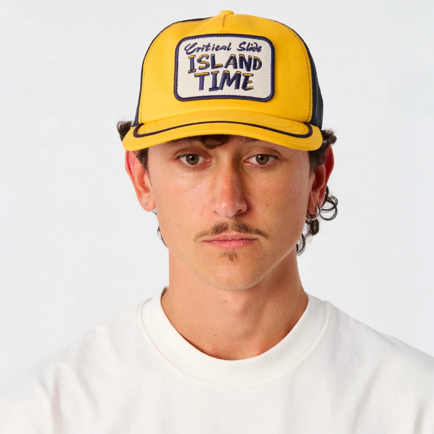 Man wearing a yellow cap with 'Island Time' text on a white background