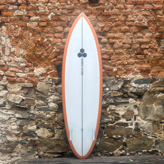Surfboard leaning against a rustic stone wall