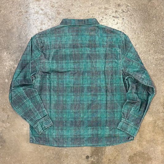 Green plaid shirt on a textured concrete surface