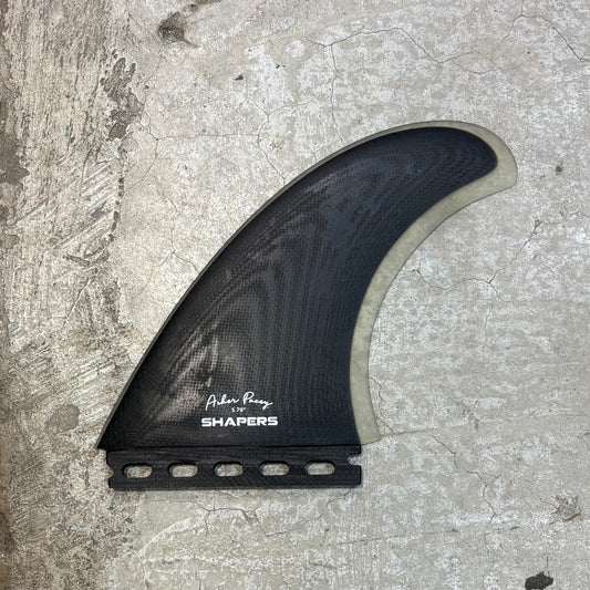 Black surf fin with 'Shapers' branding on a textured surface