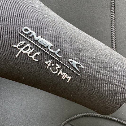 Close-up of a dark gray nwetsuit sleeve with silver foil branding that reads 'ONEILL epic 4:3MM' on textured neoprene fabric.