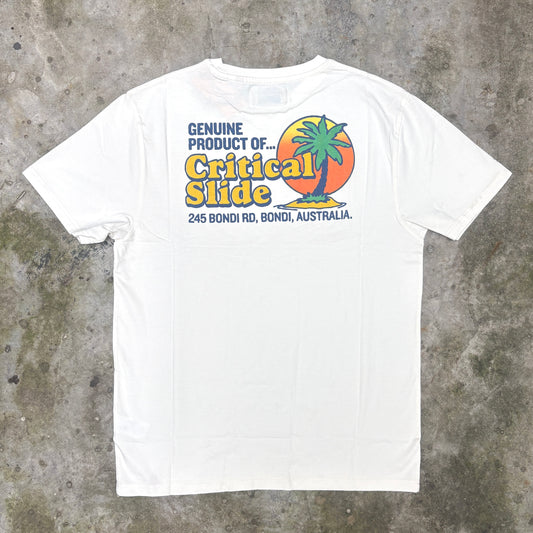 A white short-sleeve t-shirt laid flat on a textured gray concrete surface, featuring a colorful graphic print on the chest with a palm tree, sunset, and the text 'Genuine Product of Critical Slide'.