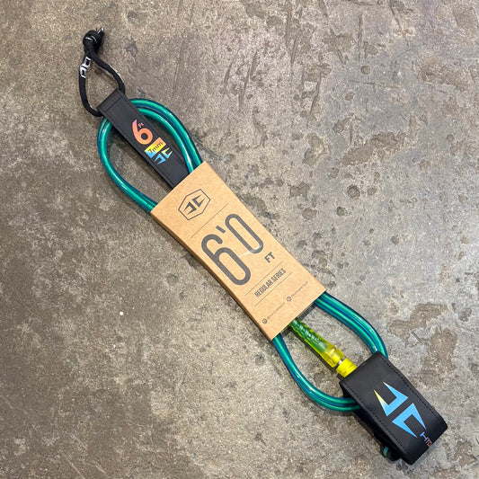 Surfboard leash with brand label on a concrete surface