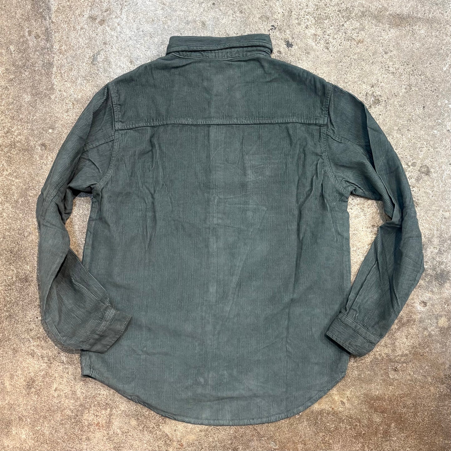 Green shirt on a textured concrete surface