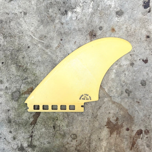 Yellow surf fin on a textured gray surface