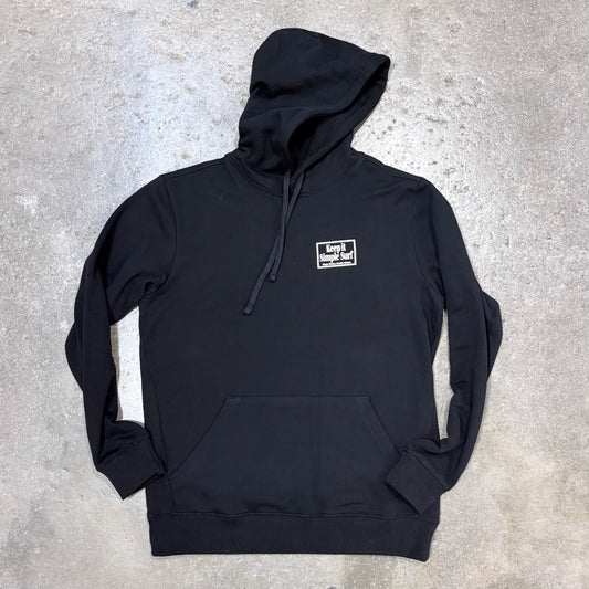 Black hoodie with a small logo on a gray concrete surface
