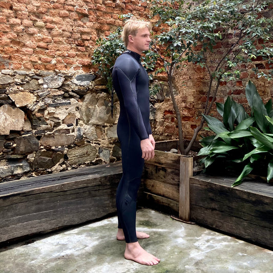 Side view of the O'Neill Hyperfreak Fire 4/3MM+ Back Zip- Worn by model - Black- Men's Wetsuit