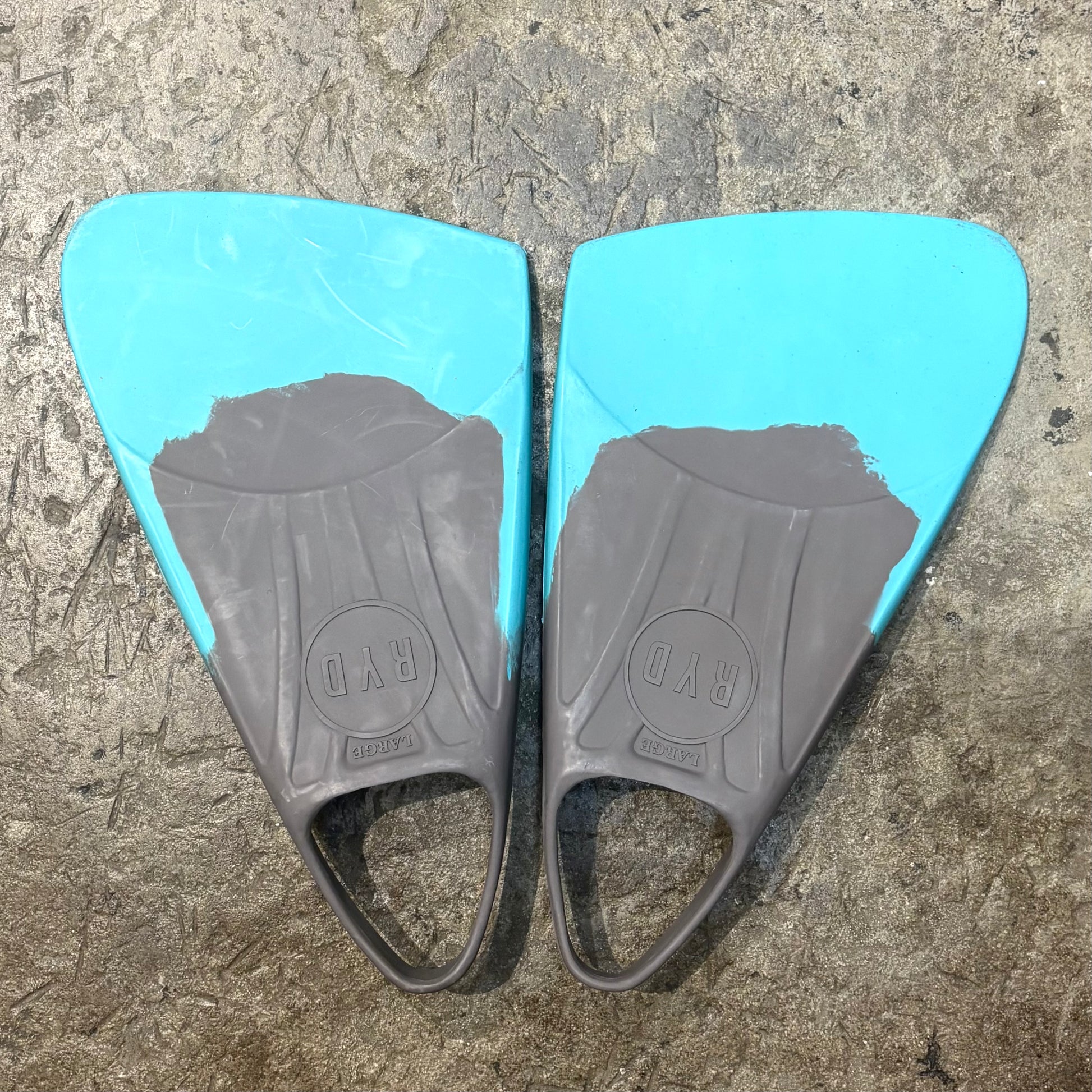 Pair of blue and gray swim fins on a textured surface
