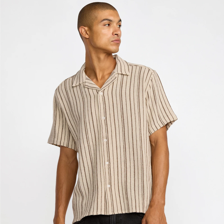 Man wearing a beige and white striped shirt against a plain background