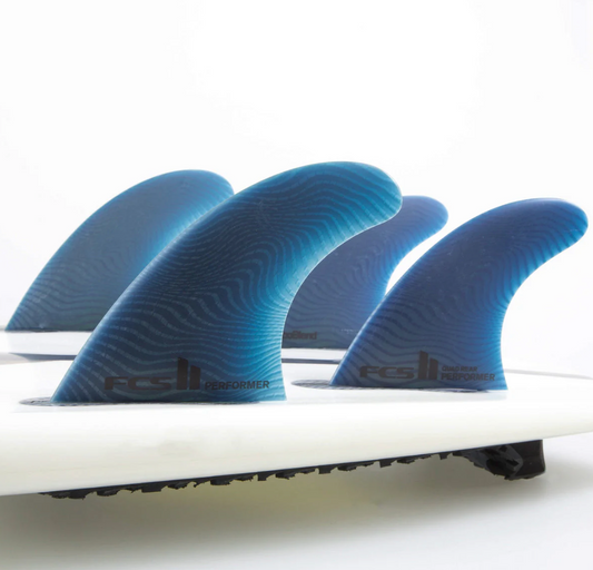 Four Blue FCS Fins on a Surfboard