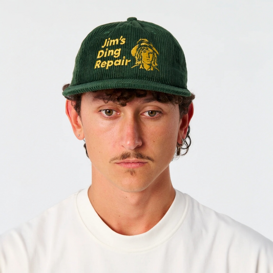 Person wearing a green cap with 'Jim's Ding Repair' text and logo on a white background
