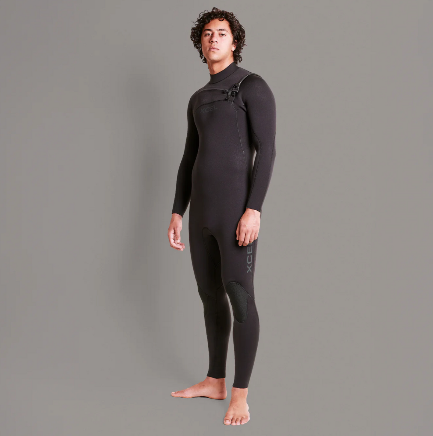 Side view stock shot of model wearing the Xcel Comp+ 4/3mm - Black - Men's Full Suit