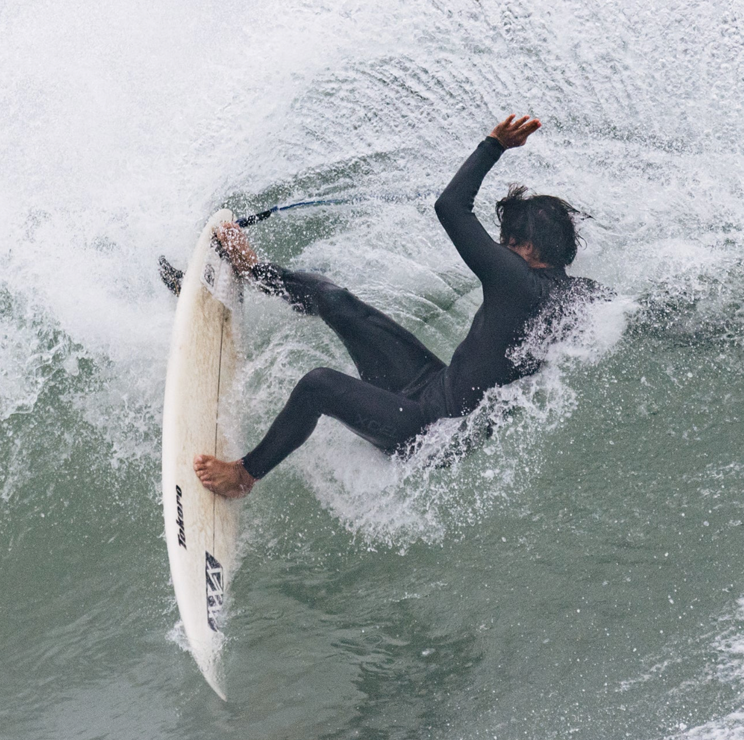 Surfer wearing the Xcel Comp+ 4/3mm showing the flexibility - Black - Men's Full Suit