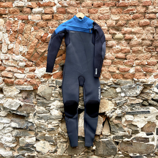 Front view of the O'Neill Youth Hyperfreak 4/3mm+ Chest Zip against brick wall - Black and Blue - Kid's wetsuit