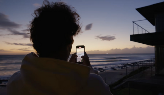 Jordy Smith taking a picture on a cellphone from the waves at Jeffreys Bay