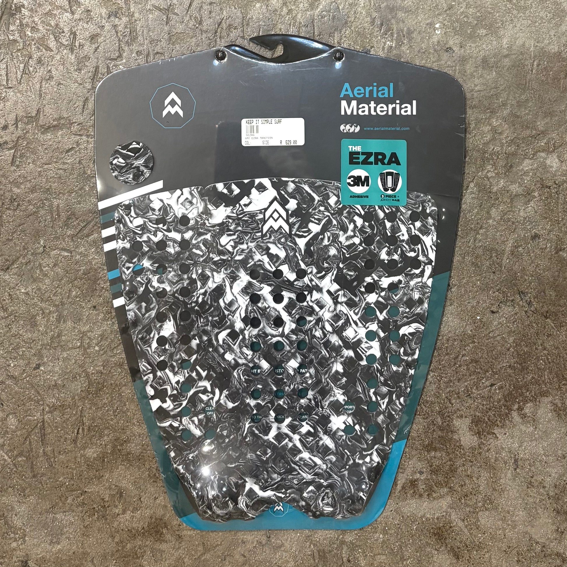 Surfboard tail pad with patterned design on a textured surface