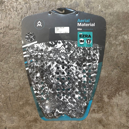 Surfboard tail pad with patterned design on a textured surface