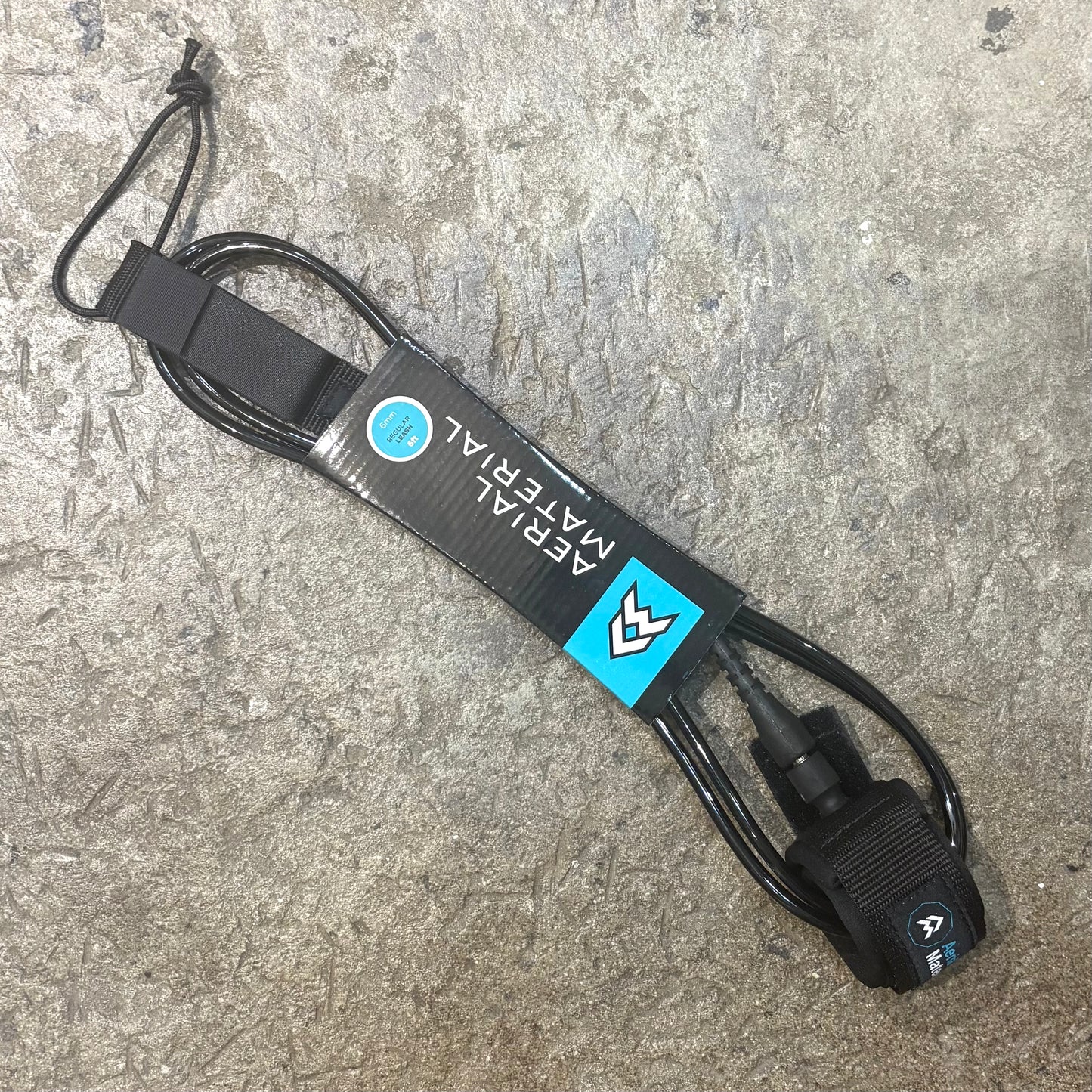 Black leash with brand logo on a textured surface