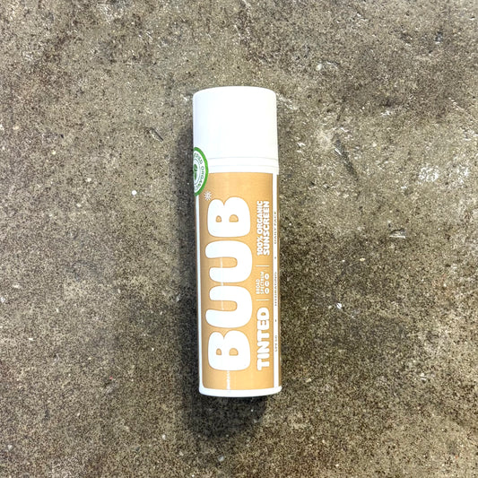 Lip balm tube labeled 'BUUB' on a textured surface