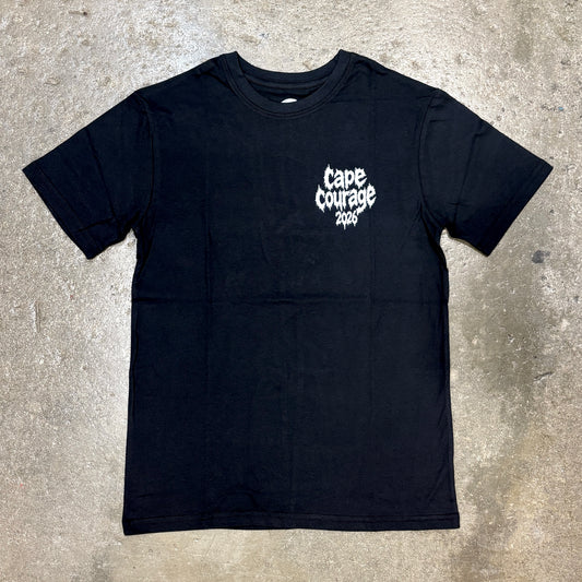 A black short-sleeve t-shirt with a white 'Cape Courage 2026' graphic printed on the left chest, laid flat on a textured concrete surface.