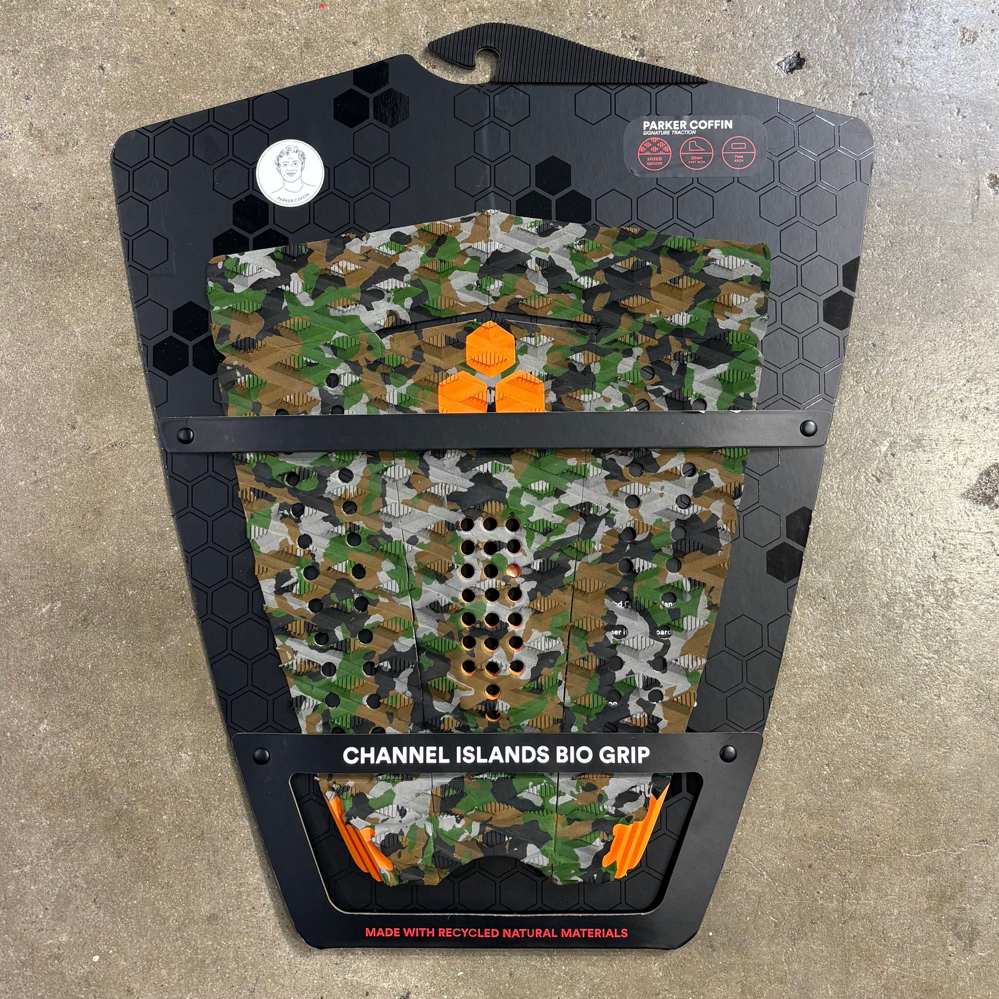Camouflage-patterned grip pad with branding on a concrete surface