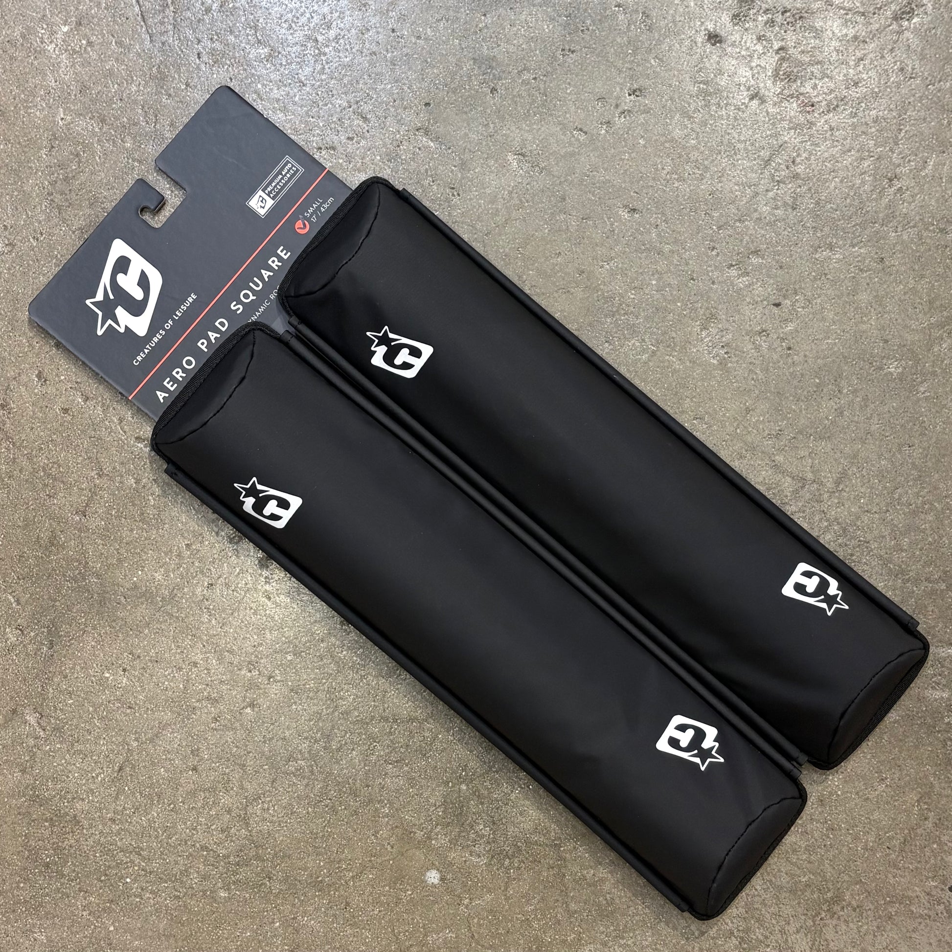 Black protective gear with a brand logo on a concrete surface