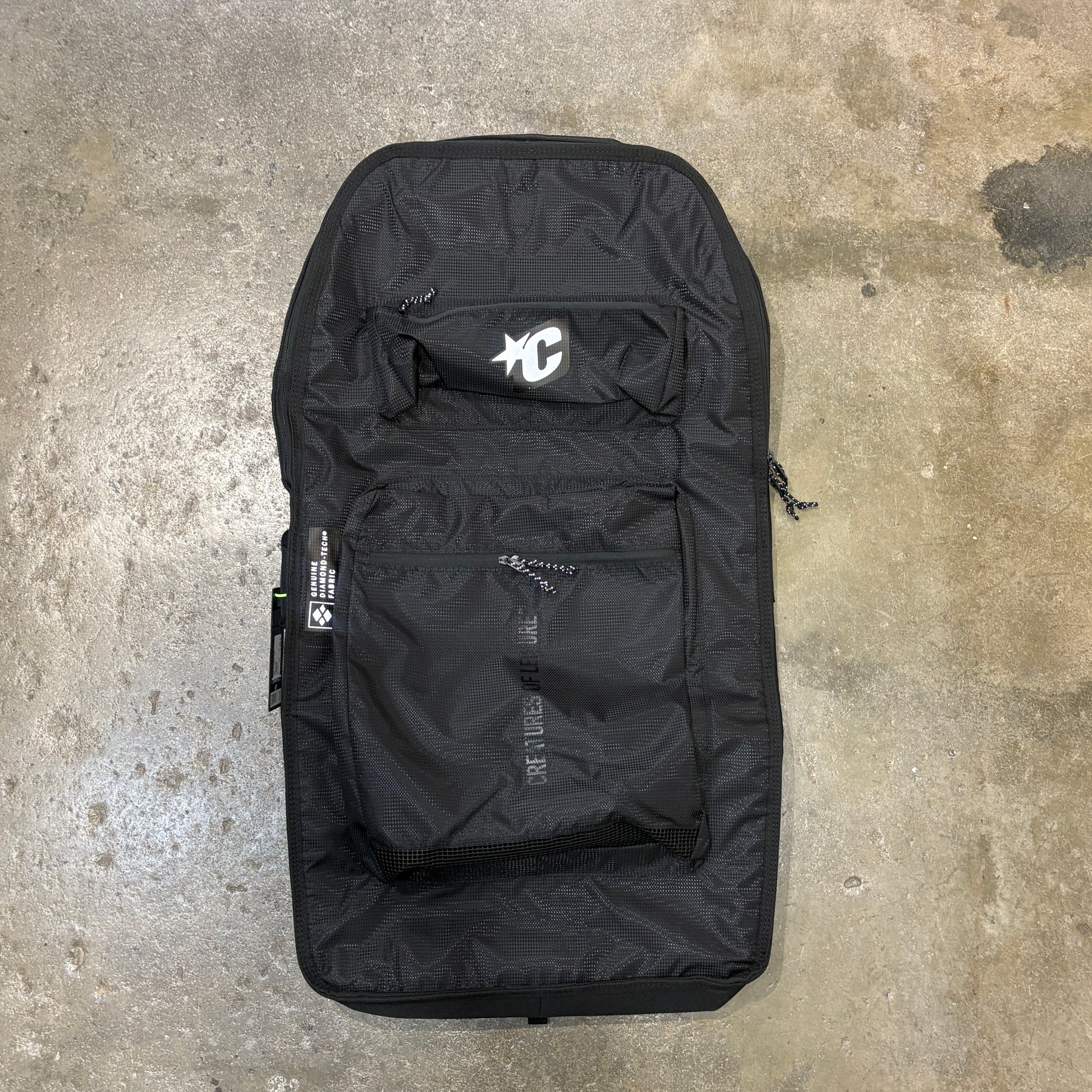Black guitar case with brand logo on a concrete floor