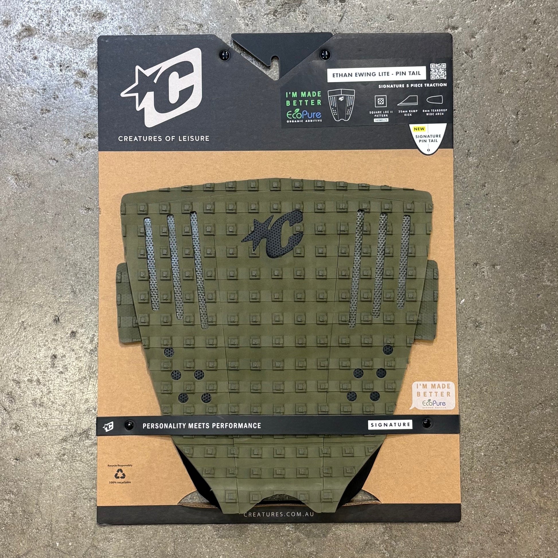Green textured pad with brand logo on a cardboard backing against a concrete background