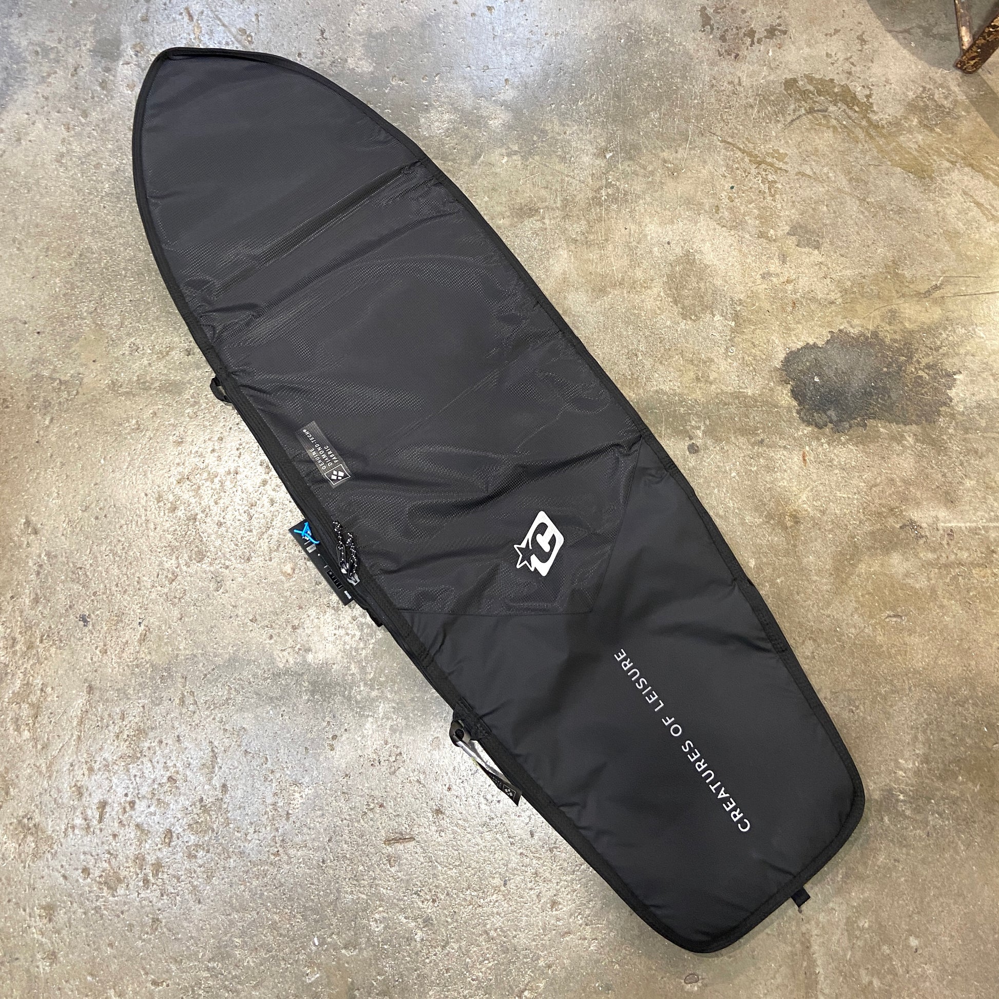 Black Creatures of Leisure Fish Day Use DT2.0 Boardbag on grey floor