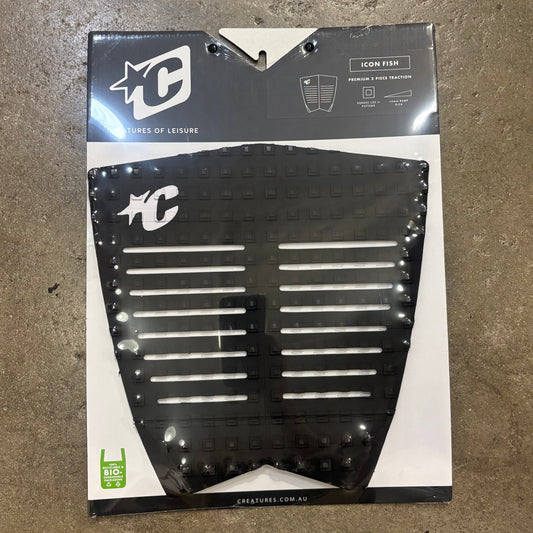 Packaged black surfboard traction pad with brand logo on a concrete surface
