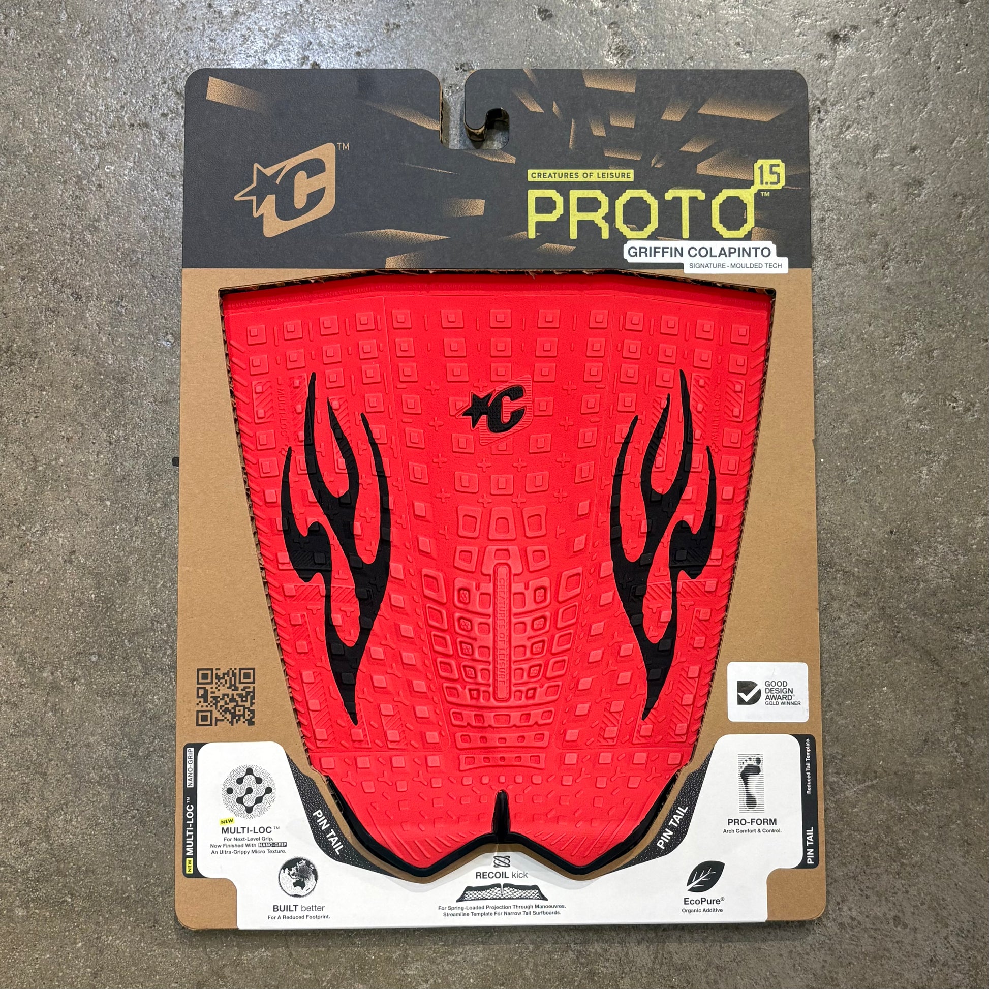 Red surfboard traction pad with black flame design in packaging on a concrete surface