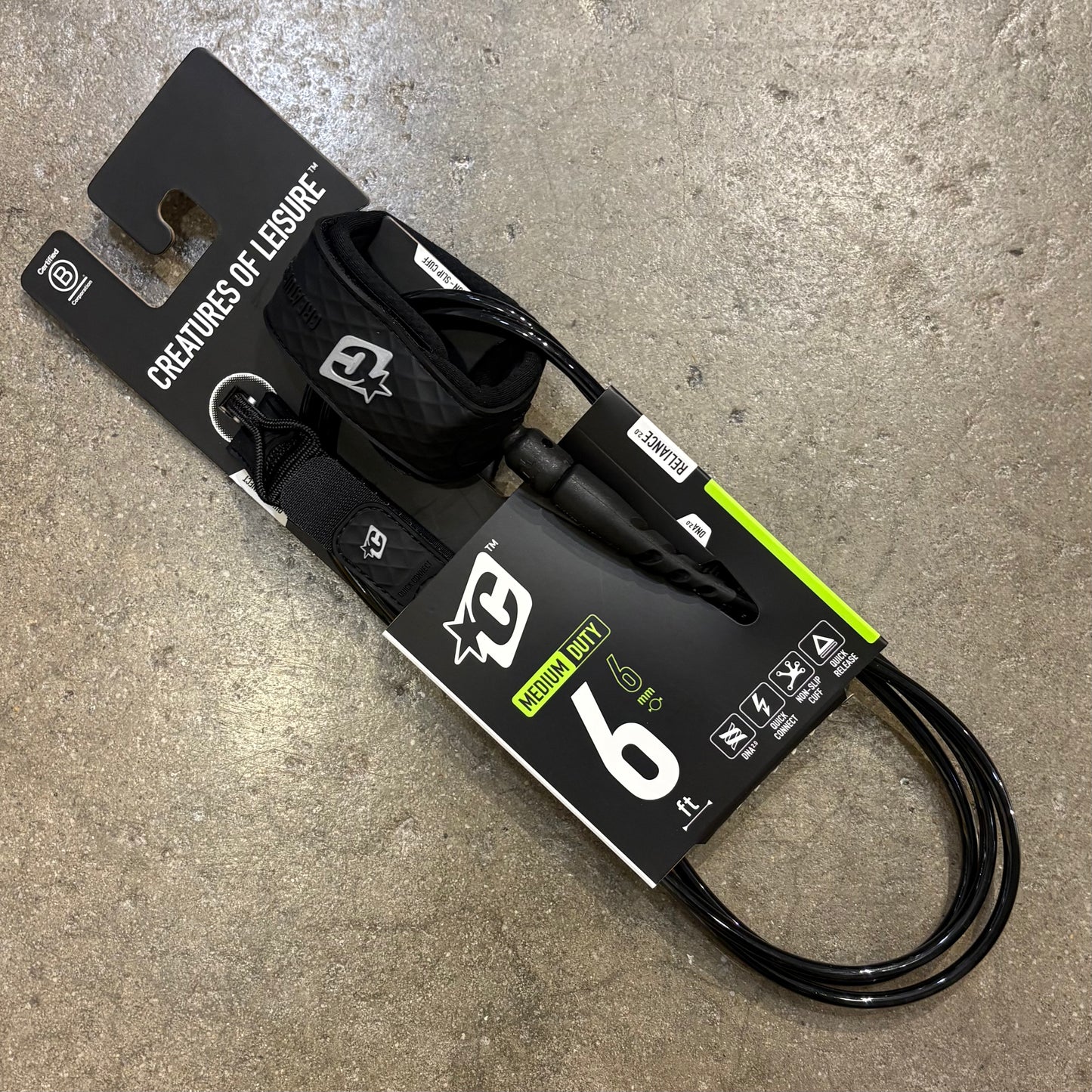 Black leash with packaging on a concrete surface