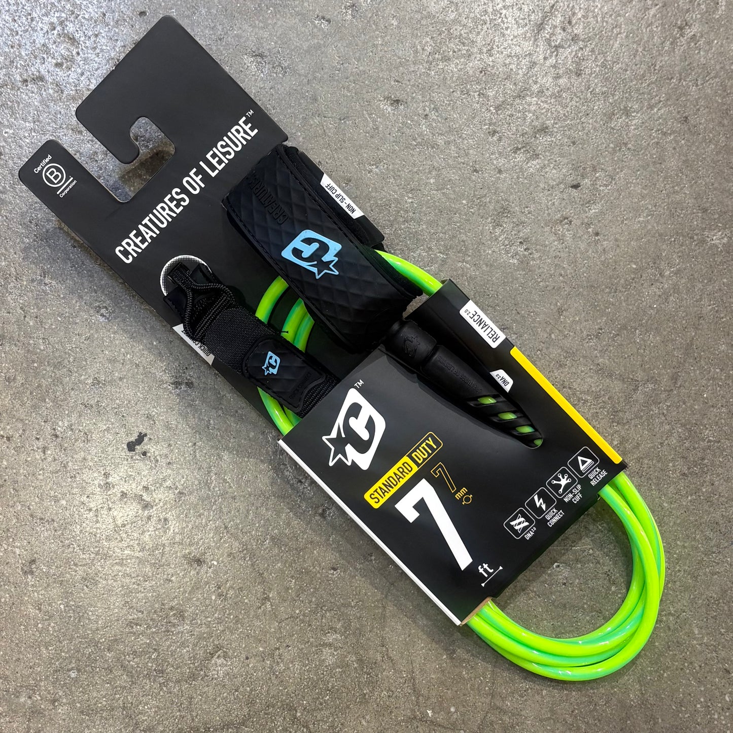 Neon green and black dog leash with packaging on a concrete surface