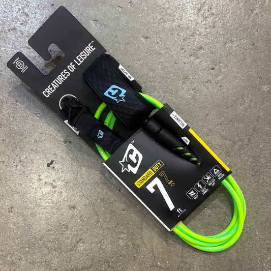 Neon green and black dog leash with packaging on a concrete surface