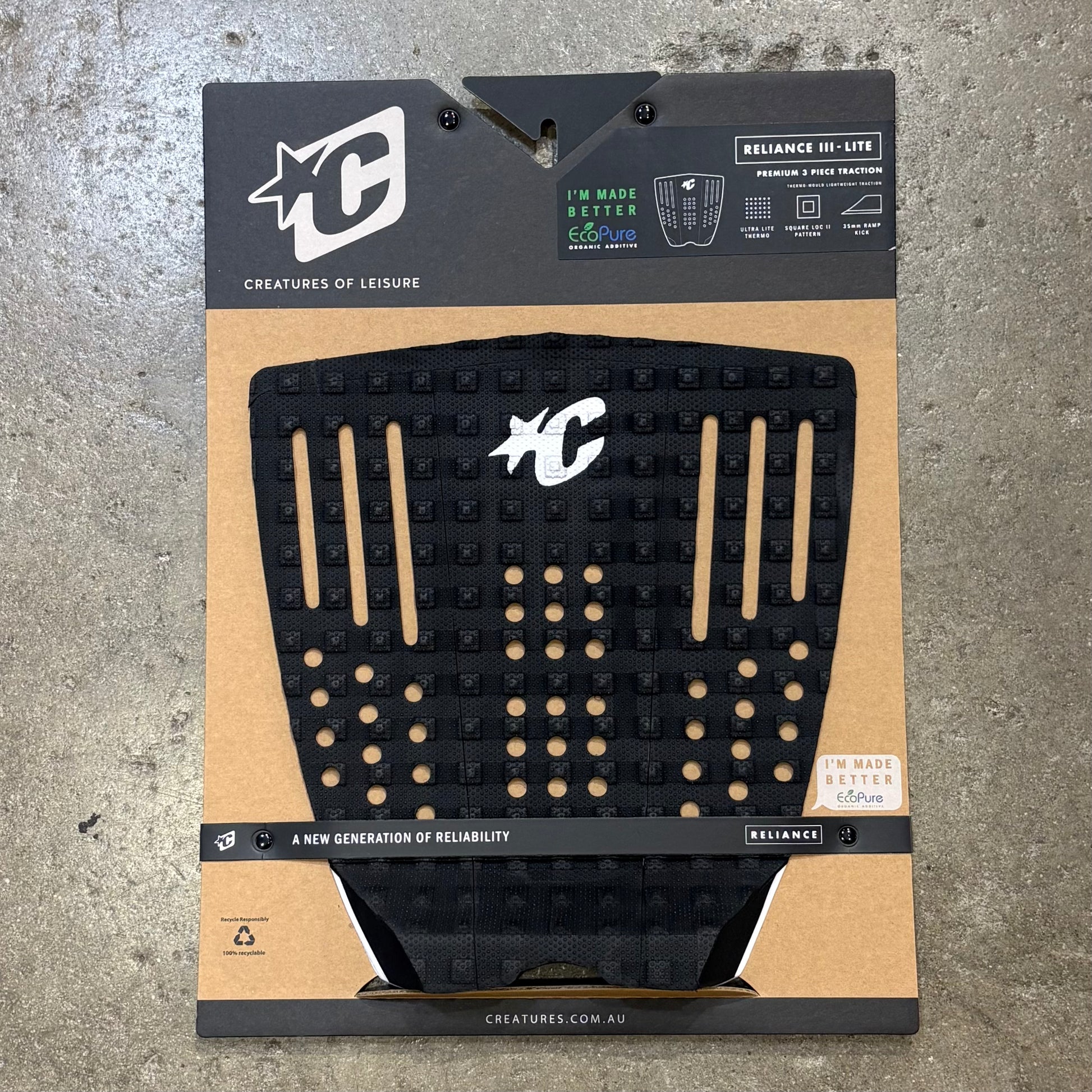 Black textured pad on a cardboard packaging with brand logos on a concrete surface