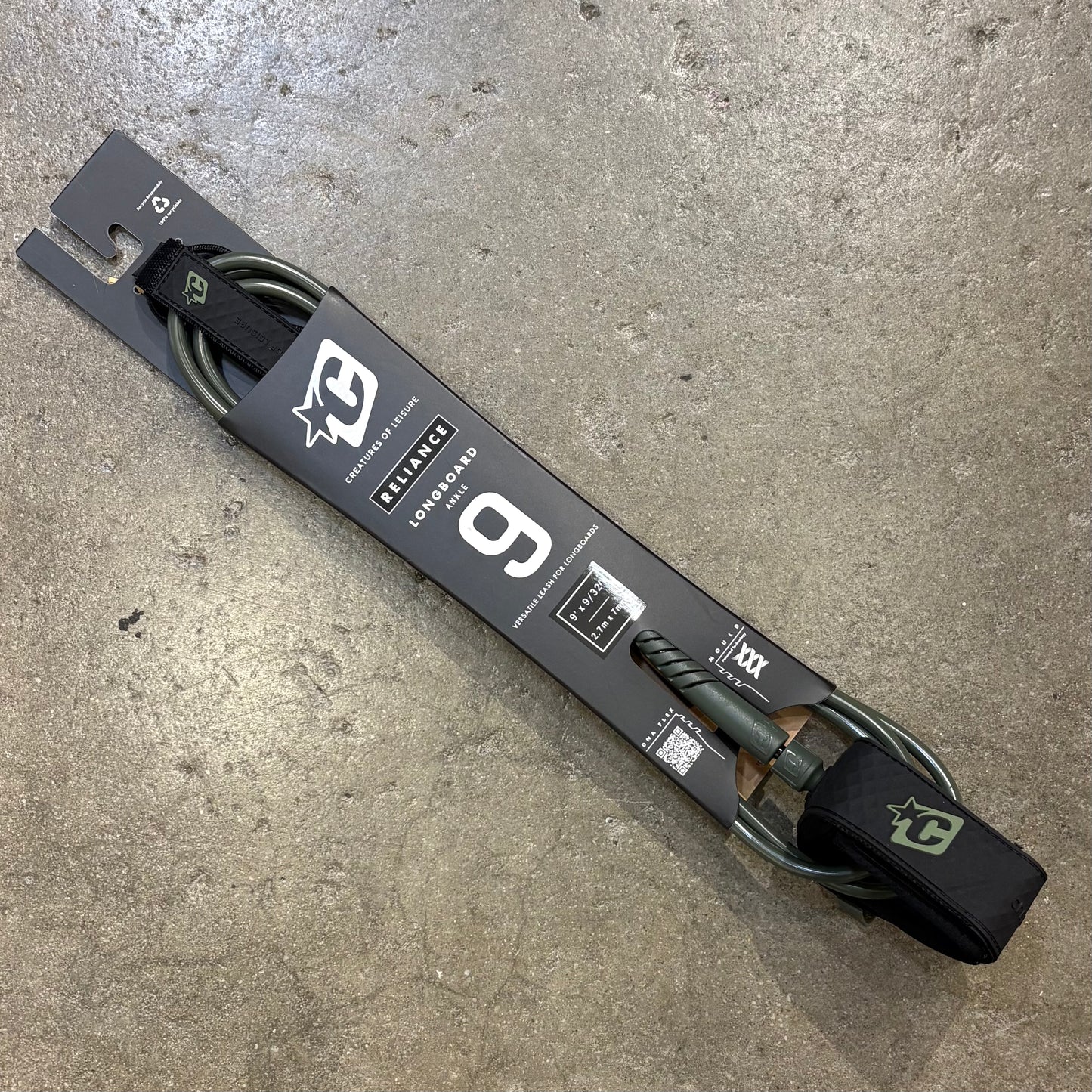 Surfboard leash for Longboards in packaging on a concrete surface