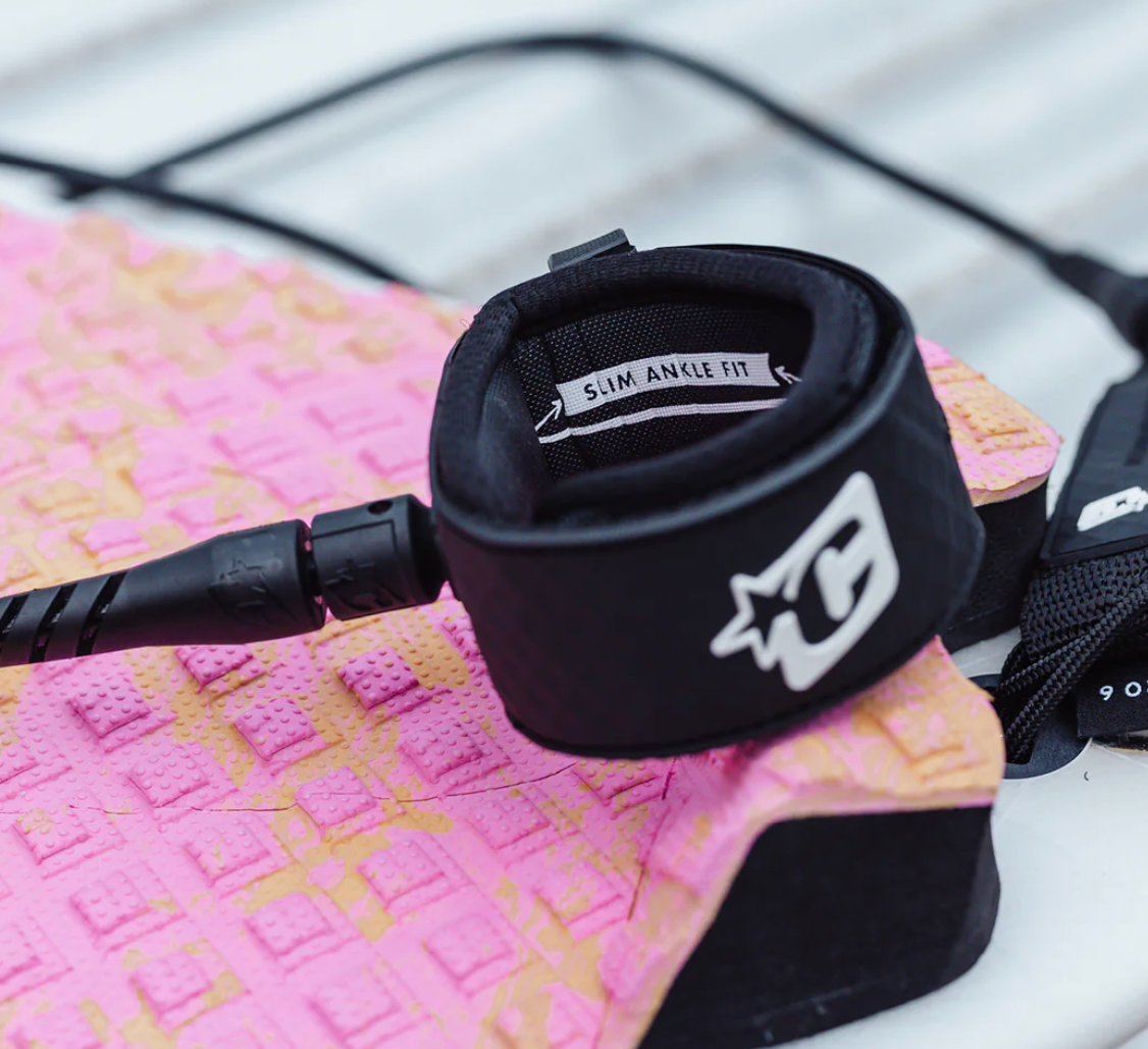 Black leash with a brand logo on a pink textured surface