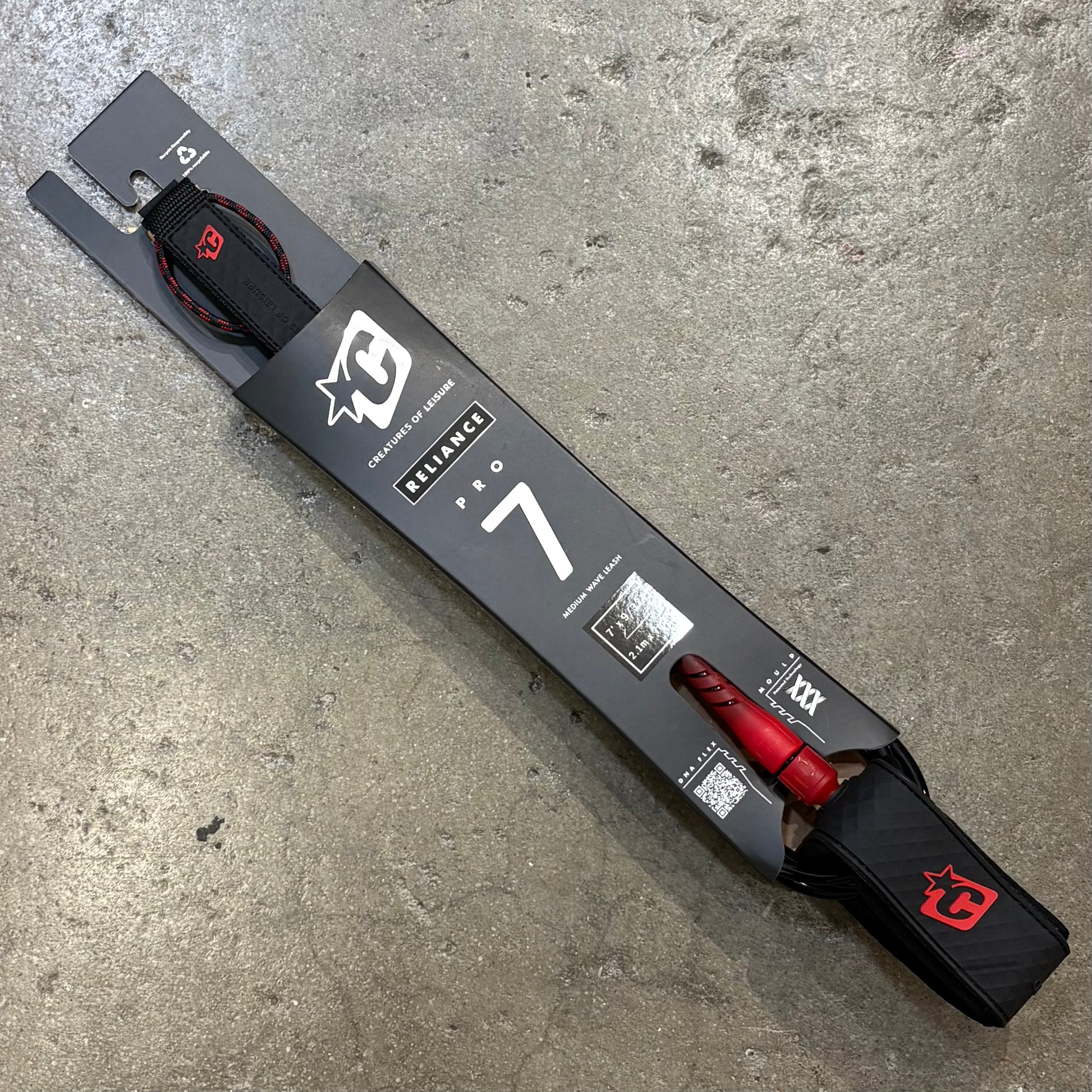 Black and red ski with packaging on a concrete surface