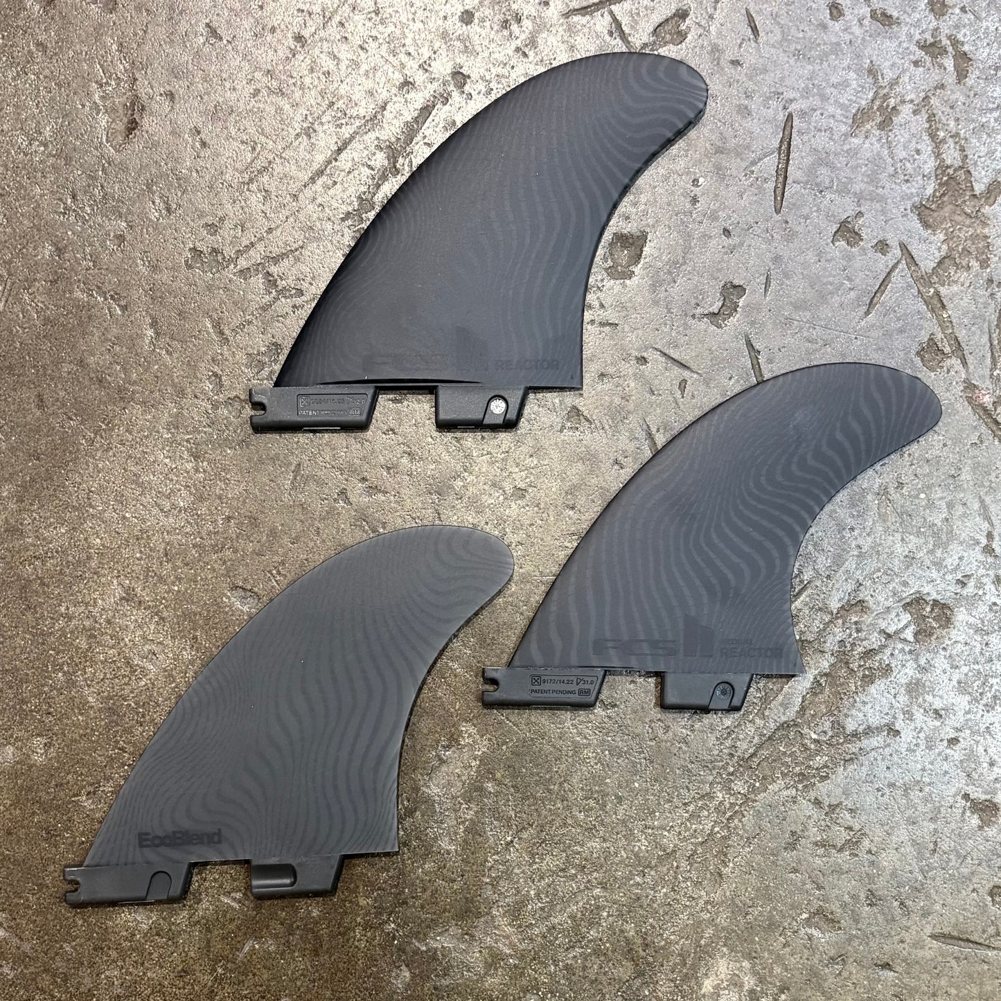 Three black fins on a concrete surface