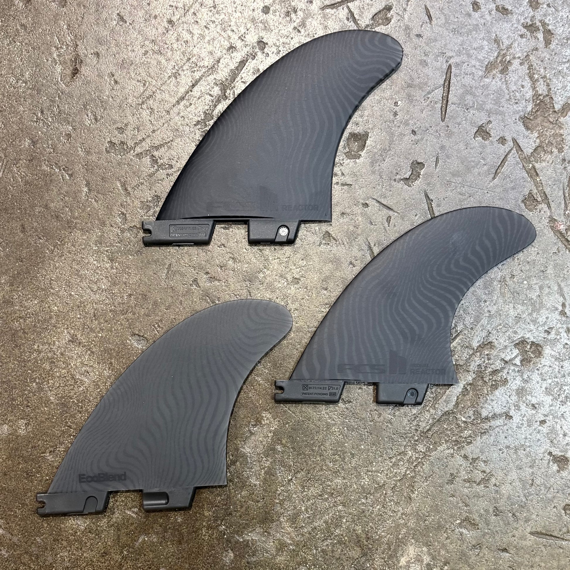 Three black fins on a concrete surface