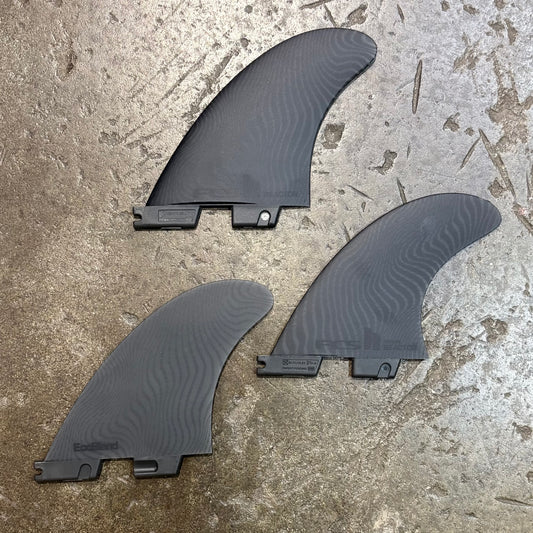 Three black fins on a concrete surface